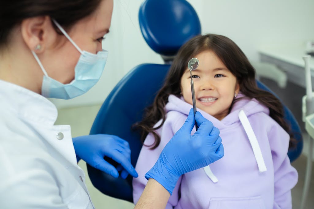 A dentist and a smiling child during a friendly dental check-up in a clinic.
