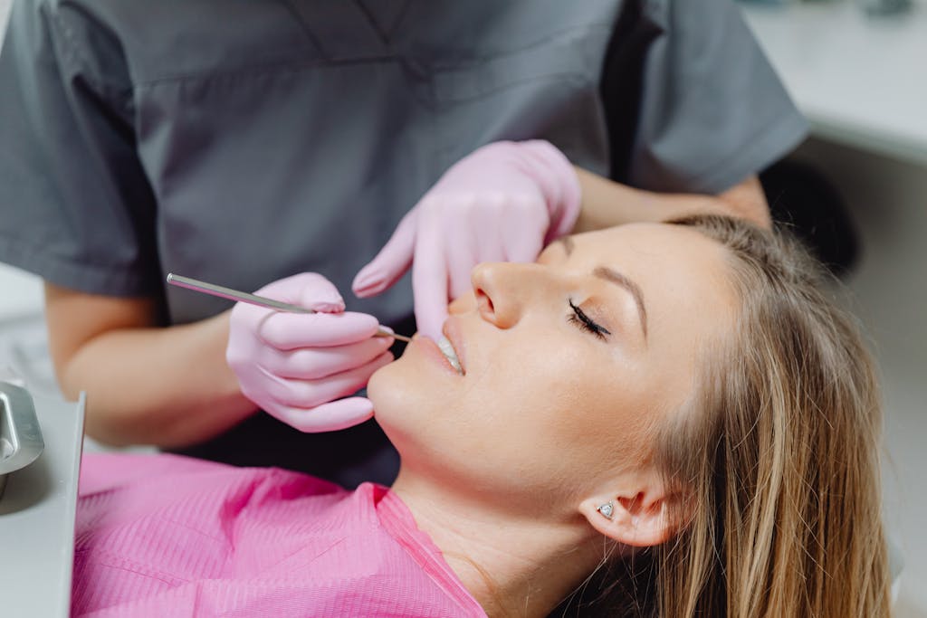 A female patient receives a dental examination by a dentist in a clinic.