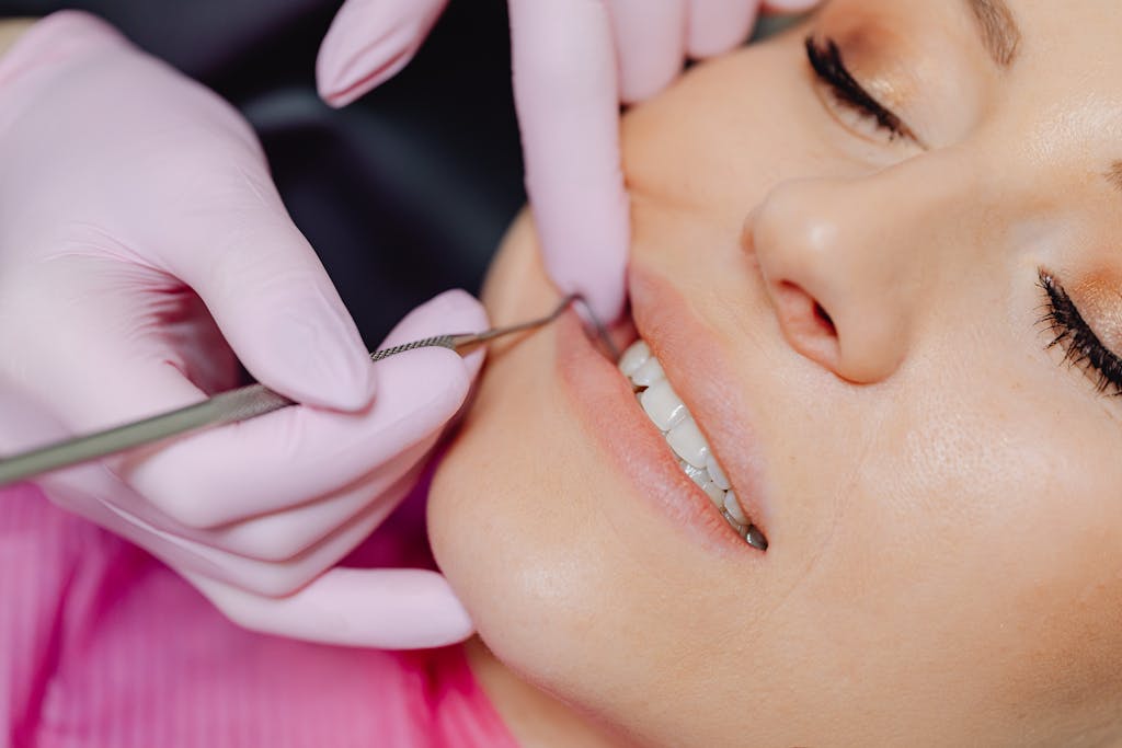 Close-up of a dental checkup showing tools and patient's mouth with a blurred background.