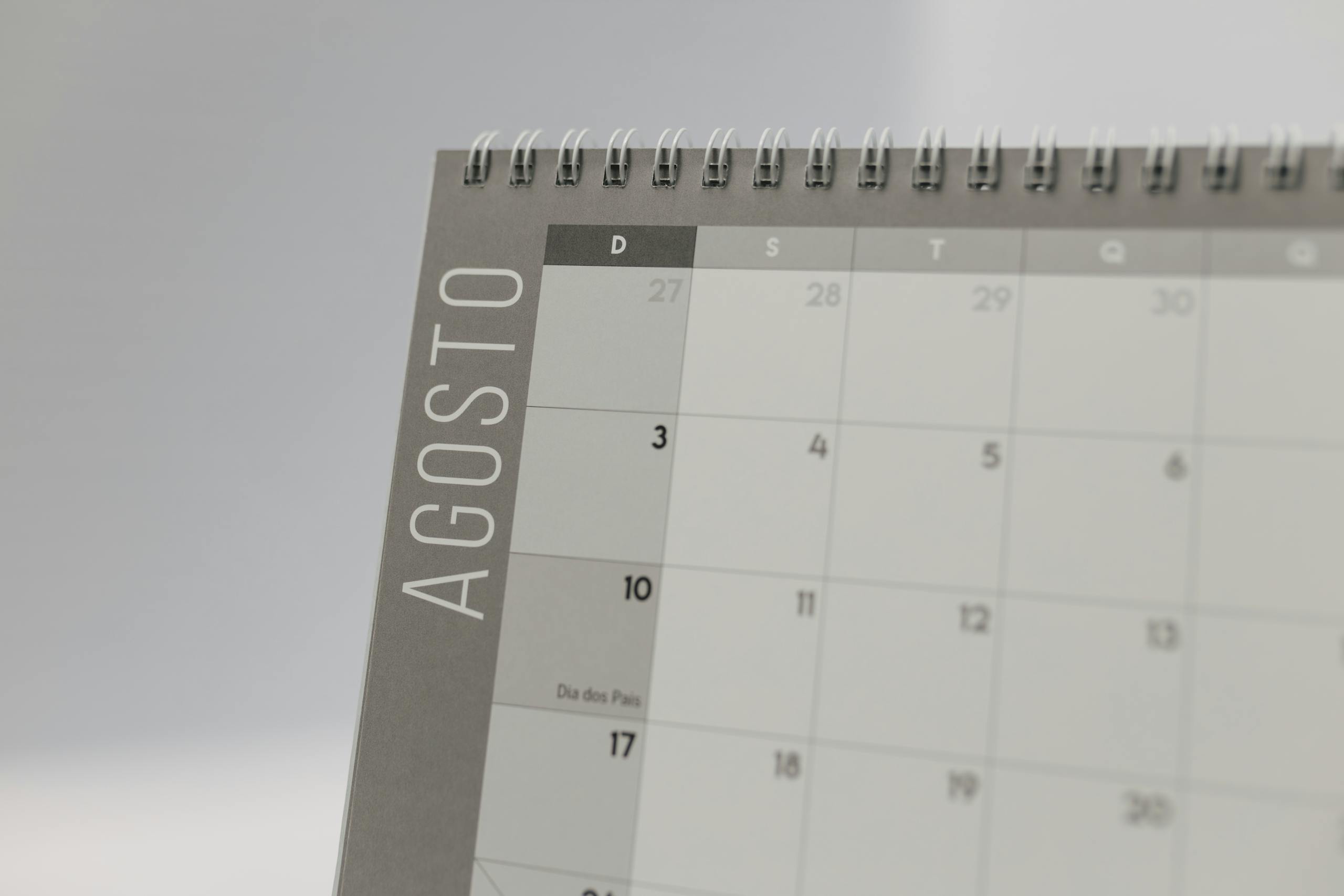 Close-up of a spiral-bound calendar highlighting August dates.